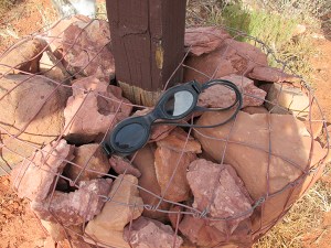 Doggles sitting on a trail cairn