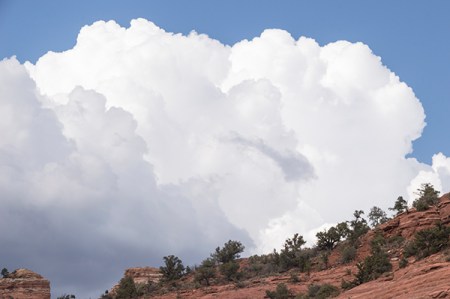 Thunder clouds forming behind a hill