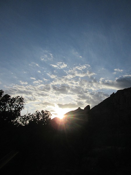 Sun setting behind rocks