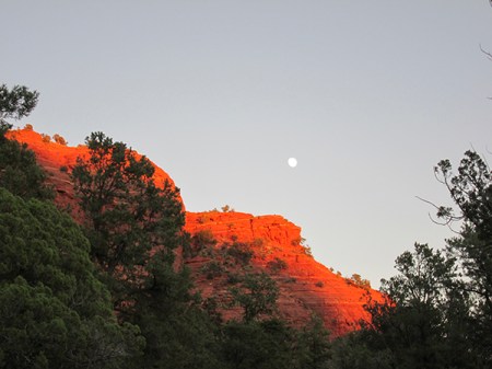 Sugarloaf lit up with the moon above it